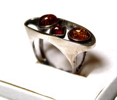 This is beautiful vintage 1990s Baltic Sea Genuine Amber ring hand set in 925 sterling silver in Poland.   The colors might look slightly different on the pictures. Sizes available: 6.5, 7, 7.25 and 7.5; size of silver setting 1.25 x 0.4''; amber stones 0.2-0.3''; weight 6.2G. Handmade in Poland and ship from Texas USA. Amber is the fossilized, hardened resin of trees, ranging in age from less than a million to more than 300 million years old. This beautiful Baltic Amber has been popular throughout the World for Centuries and is reflected in many of the regions folk tales. Amber Jewels are actually pieces of petrified tree sap and found in only three areas throughout the World. Occasionally, you may find pieces of insects or plants trapped inside these jewels but they are quite rare. Amber Vintage Amber Rings For Anniversary, Retro Silver Rings For Formal Occasions, Retro Style Silver Rings For Formal Occasions, Retro Silver Rings For Collectors, Retro Silver Rings For Anniversary, Silver Retro Rings For Anniversary, Silver Retro Anniversary Rings, Tree Sap, Antique Jewelry Rings