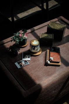 a wooden table topped with pictures and other items