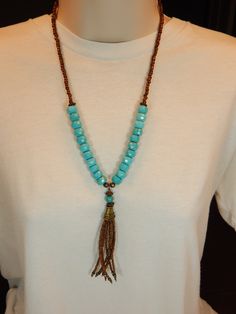 An attractive turquoise tassel necklace. Turquoise rondelles are foundation of this necklace. The tassel is of antique gold finish seed beads with tiny turquoise colored crystals. The gold seed beads at the ends of the necklace make it more comfortable to wear. The necklace is 22 inches long plus the 4.5 inches tassel. It is held with a handmade hook clasp. Turquoise Jewelry With Tassels And Round Beads, Adjustable Turquoise Tassel Necklaces, Turquoise Beaded Necklaces With Tassels For Gift, Turquoise Necklace With Tassels And Round Beads, Turquoise Necklaces With Tassel And Round Beads, Turquoise Beaded Necklace With Tassels And Round Beads, Turquoise Beaded Necklace With Tassels, Adjustable Turquoise Tassel Necklace With Round Beads, Turquoise Beaded Necklace With Tassels, Bohemian Style