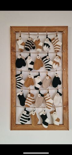 a wooden frame filled with knitted christmas ornaments