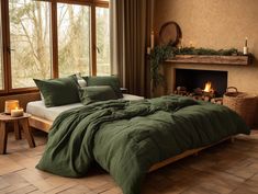 a bed with green comforter and pillows next to a fireplace