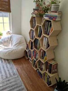 a living room filled with lots of furniture and bookshelves next to a window