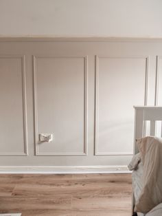 a baby's room with white walls and wooden floors