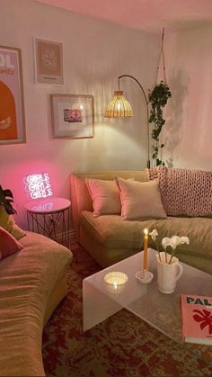 a living room filled with furniture and a pink light on the wall above it's coffee table