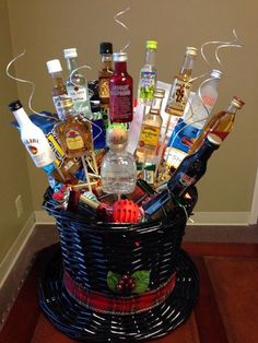 a wicker basket filled with liquor bottles and condiments on top of a wooden floor