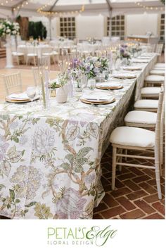 an image of a table set up for a wedding reception with flowers and greenery