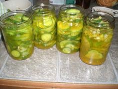 several jars filled with pickles sitting on top of a counter