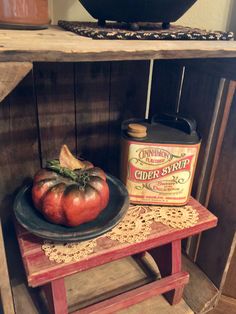 an old wooden table with some tomatoes on it and a can of cider syrup