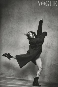 black and white photograph of a woman in an overstuffed coat dancing with her legs spread out