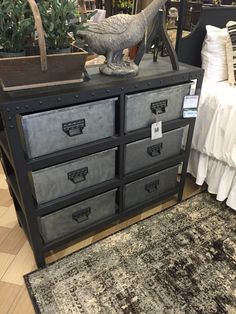 an old dresser with several drawers and a bird figurine sitting on top of it