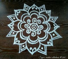 a white and brown flower on top of a wooden table