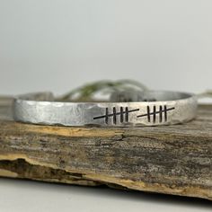 The perfect gift your wife on your 10th anniversary, this sweet cuff bracelet made with 10 tally marks to represent 10 years of marriage and handmade just for you. Your bracelet can have an inscription done on the inside to make it an even more special gift! Make that selection when adding it to your cart, and leave your message in the personalization box of through a message to me. This bracelet is 1/4 inch wide, and 6 inches in length. Looking for a 7 inch model for your husband? Click here: h Handmade Adjustable Cuff Bracelet For Anniversary, Anniversary Hand Stamped Silver Cuff Bracelet, Silver Hand Stamped Cuff Bracelet For Anniversary, Adjustable Cuff Bracelet For Anniversary, 10year Anniversary Ideas, Aluminum Bracelets, 10 Year Anniversary Gift, Tally Marks, Anniversary Gift For Wife