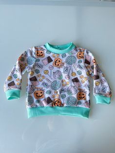 Keep your little one cozy and stylish with our Unisex Fall and Halloween Kids Sweater! This adorable orange sweater is perfect for the autumn season, featuring charming pumpkin and bat designs that celebrate the spooky spirit of Halloween. Made with soft, high-quality fabric, it ensures comfort and warmth for your baby boy or girl during chilly fall days. Ideal for baby shower gifts or adding a festive touch to your toddler's wardrobe, this sweater is designed with both style and practicality in Playful Crew Neck Fall Sweater, Playful Crew Neck Sweater For Fall, Playful Long Sleeve Sweater For Fall, Playful White Sweater For Fall, Playful Sweatshirt With Ribbed Cuffs For Fall, Playful Fall Sweatshirt With Ribbed Cuffs, Playful Green Sweatshirt For Fall, Cotton Sweater For Playtime In Fall, Cotton Sweater For Fall Playtime