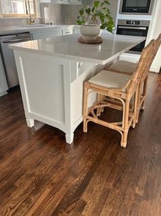 a kitchen with white cabinets and wooden floors