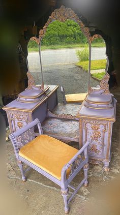 an antique vanity with mirror and stool in the middle of a parking lot next to a driveway