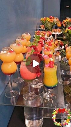 a table topped with lots of glasses filled with different types of drinks and desserts