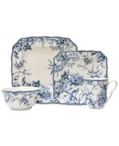 a blue and white dinner set with flowers on it