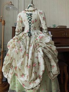 Immerse yourself in the opulent elegance of the Rococo era with our stunning Marie Antoinette-inspired ball gown. This exquisite dress, featuring a pastel green skirt and a pink floral bodice, seamlessly blends historical charm with modern sophistication, making it the perfect choice for a fairy-tale wedding. Rococo Style Elegance: This gown showcases the intricate detailing of Rococo fashion, with a structured bodice adorned with delicate lace and floral embroidery. Luxurious Craftsmanship: The Dress And Corset, Pastel Green And Pink, Corset Back Wedding Dress, Simple Satin Wedding Dress, Rococo Era, Floral Ball Gown, Nontraditional Wedding Dress, Wedding Dresses High Low, Champagne Evening Dress