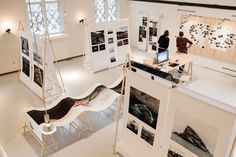 people looking at art on display in an open space with white walls and flooring