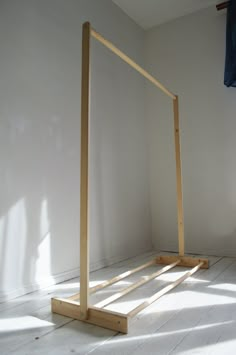 a wooden frame sitting on top of a white floor next to a blue towel rack