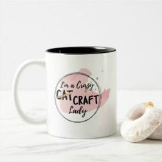 a white and black coffee mug with a donut on the side that says i'm a crazy cat craft lady