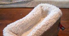 a dog bed made out of sheepskin is sitting on the floor