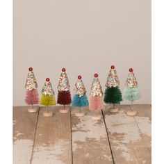 five small christmas trees are lined up on the table