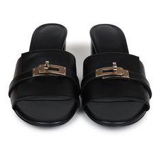 These Hermes Gigi 50 sandals are in Black calfskin leather with permabrass hardware, featuring a 2" heel, an iconic permabrass-plated Kelly buckle detail on front of sandal, natural leather soles, and are a size 37.5 EU. Origin: ItalyCondition: New and never worn (plastic on hardware)Accompanied by: Hermes box, dustbagsSize: 37.5 EU Classic Sandals With Tang Buckle In Calf Leather, Calf Leather Open Toe Heels With Tang Buckle, Open Toe Calf Leather Heels With Tang Buckle, Luxury Calf Leather Mules With Buckle Closure, Chic Calf Leather Sandals With Tang Buckle, Luxury Formal Mules With Tang Buckle, Luxury Summer Mules With Buckle Closure, Calf Leather Sandals With Tang Buckle, Luxury Heels With Tang Buckle