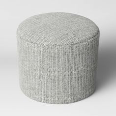 a small round ottoman sitting on top of a white floor