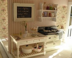 a dollhouse kitchen with pink and white wallpaper, stove top oven and shelves