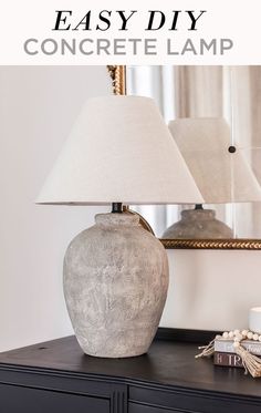 a lamp sitting on top of a table next to a dresser and mirror with text overlay that reads easy diy concrete lamp