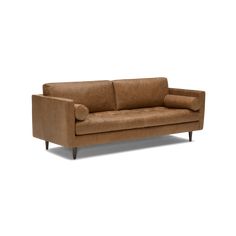 a brown leather couch sitting on top of a white floor