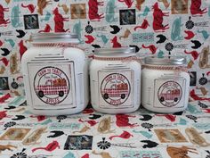 three white jars sitting on top of a table