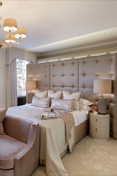 a large bed sitting in the middle of a bedroom next to two lamps on either side of it