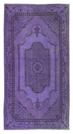 a purple rug with an ornate design on the center and sides, in different colors