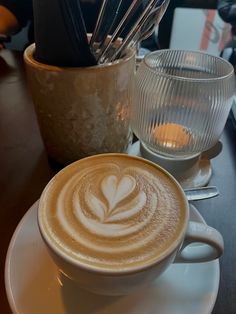 a cappuccino on a saucer with spoons in the shape of a heart