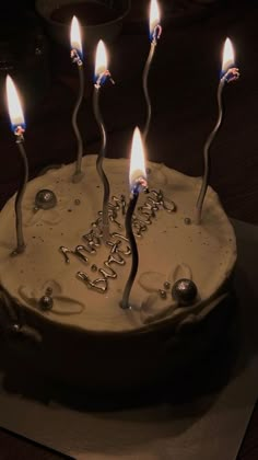 a birthday cake with lit candles on it