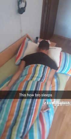 a man laying in bed with his head on the pillow that is covering him and sleeping