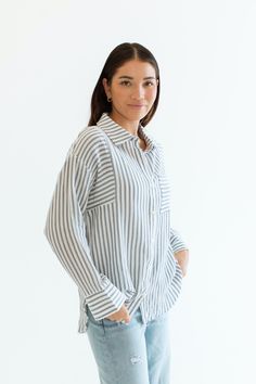 Stay cool and stylish this summer with our Zuma Button Down, featuring pretty iridescent buttons and a raw hem. This super lightweight top offers an effortless, relaxed, and roomy fit, making it perfect for warm weather. Best of all? Its 100% cotton! Wear it buttoned up for a polished look or unbuttoned over a swimsuit or tank for a breezy, casual vibe. This versatile piece is a must have summer staple! Malibu Collection FIT Relaxed Roomy Fit Iridescent Buttons High-Low Raw Hem Clancy is 5'9 Wea Casual Striped Linen Tops, Striped Linen Top With Button Closure, Vacation Button-up Tops With Button Cuffs, Button-up Tops With Button Cuffs For Vacation, Versatile Shirt For Day Out With Buttons, Versatile Shirt With Buttons For Day Out, Versatile Everyday Tops With Button Cuffs, Versatile Shirt For Day Out, Linen Tops With Button Closure For Vacation