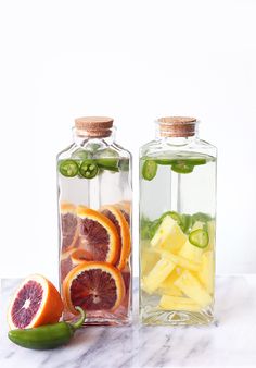 two bottles filled with different types of fruit