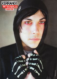 a young man wearing a black and white striped hoodie holding his hands up to his face