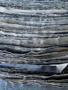 a pile of old blue jeans that have been washed and are stacked up to dry