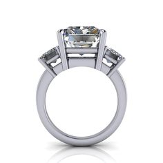 Solid Silver Cocktail ring shown with a 12x10mm, 8.00 ct. radiant cut colorless simulated diamond and (2) 7x5mm emerald cut colorless simulated diamonds, 2.00 ct. Band width 2.2mm.10.00 carat total weight. *Sterling Silver is Rhodium dipped to reduce tarnishing. Rhodium is a very strong metal that creates a protective layer over the sterling silver, making it more resistant to tarnishing. *Custom made at the time of order. Modern Radiant Cut Diamond Jewelry, Modern Radiant Cut Cubic Zirconia Wedding Jewelry, Modern Emerald Cut Moissanite Jewelry, Modern Cushion Cut Diamond Ring As Gift, Radiant Cut Platinum Jewelry With Prong Setting, Modern Square Cut Diamond Jewelry, Diamond White Three-stone Emerald Cut Jewelry, Silver Moissanite Diamond Ring Rectangular, Rectangular Three Stone Diamond Jewelry