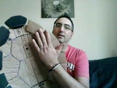 a man sitting on top of a couch next to a cardboard wall with his hands in the air