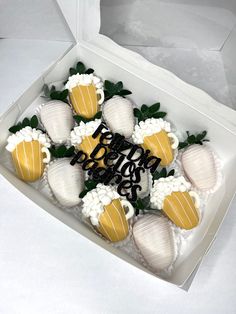 a box filled with lots of white and yellow desserts on top of a table