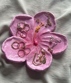 a pink flower with lots of rings on it sitting on top of a white sheet