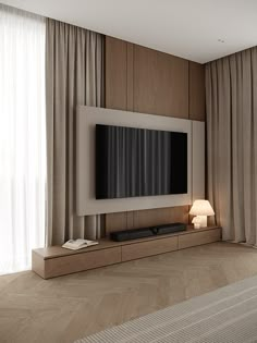 a living room with a flat screen tv mounted on the wall next to a lamp