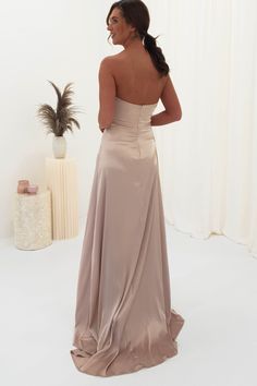 the back of a woman in a long dress looking down at her shoulder and shoulders