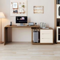 a desk with a computer on top of it in front of a wall filled with pictures