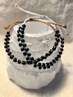 Black seed beads braided onto tan and white waxed polyester string with a square knot slide closure. Multicolor Bracelet, Black Beaded Bracelets, Seed Bead Bracelet, Black Seed, Black Bracelets, String Bracelet, Quartz Bracelet